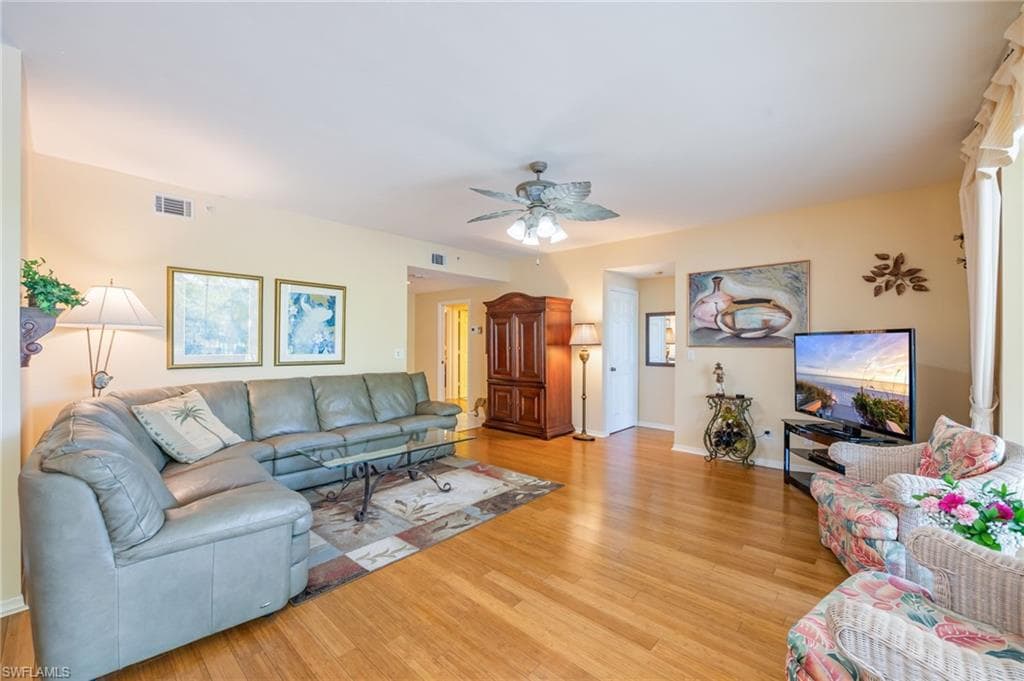 Living room featuring light wood-type flooring and a ceiling fan