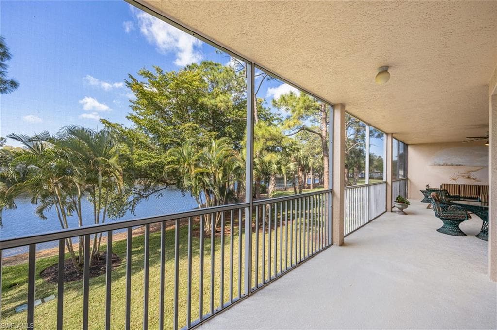 Unfurnished sunroom with a balcony and a water view