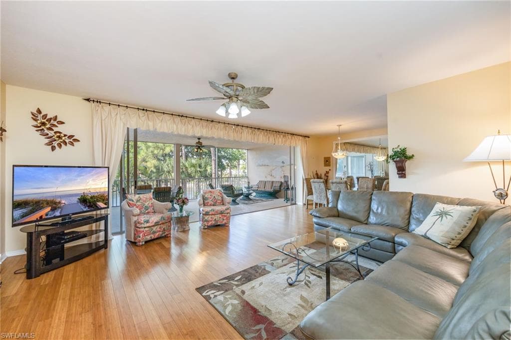 Living room with ceiling fan and light wood-type flooring