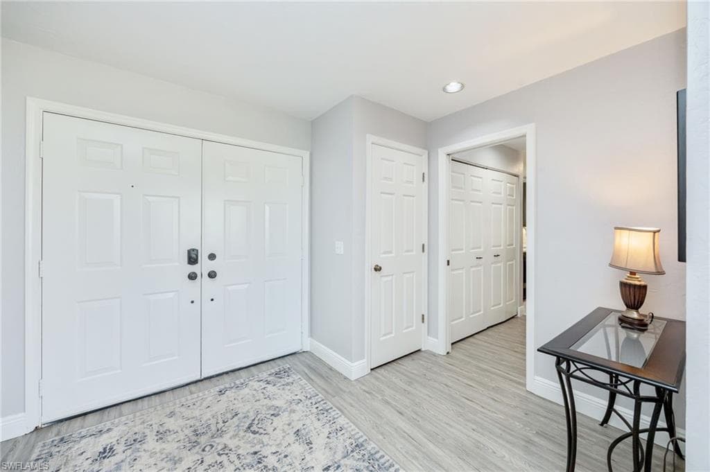 Entryway featuring baseboards and light wood-type flooring