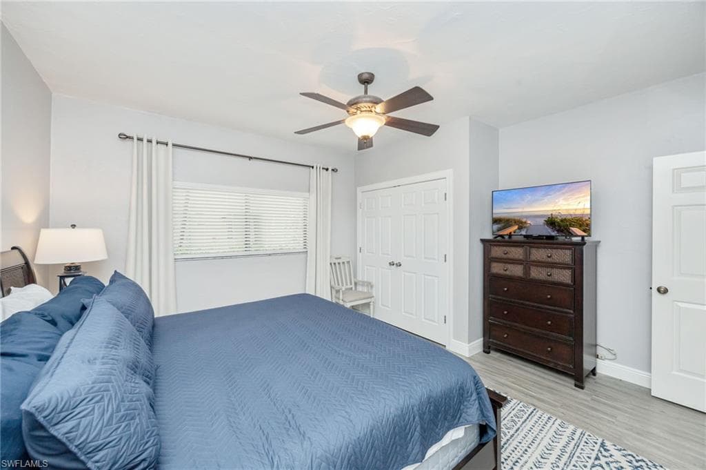 Bedroom with a closet, a ceiling fan, and wood finished floors