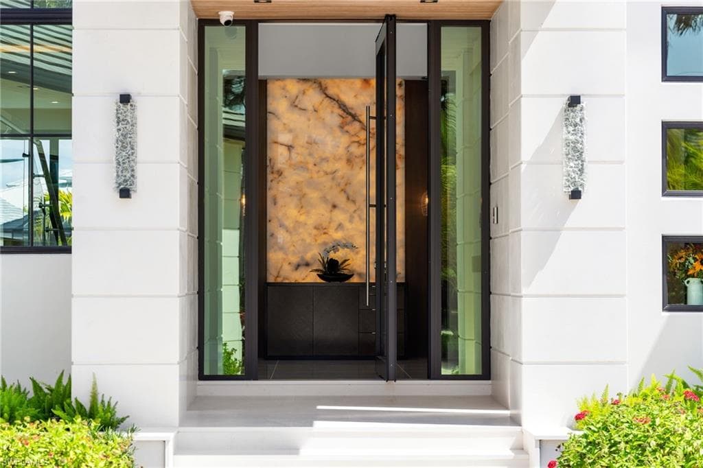 View of exterior entry with stone siding and stucco siding