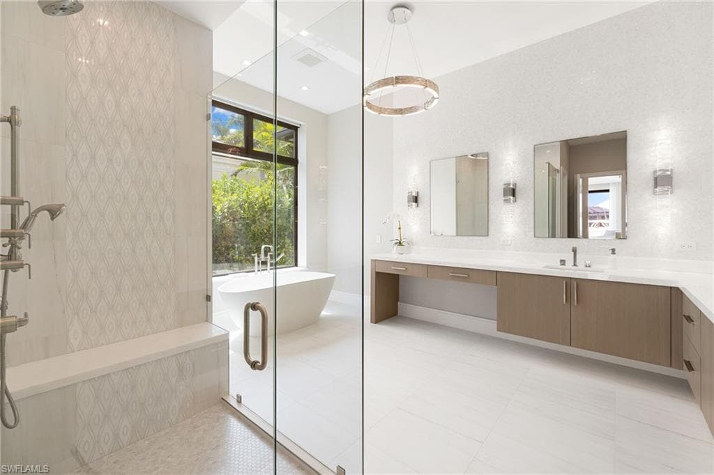 Full bathroom with vanity, tiled shower, a soaking tub, and recessed lighting