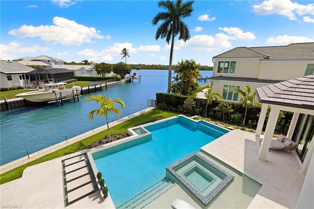 Integrated pool / hot tub featuring a patio, a water view, a dock, and a gazebo