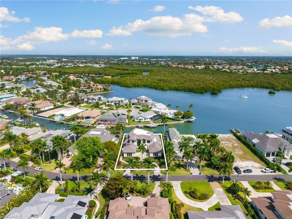 Aerial perspective of suburban area featuring a nearby body of water