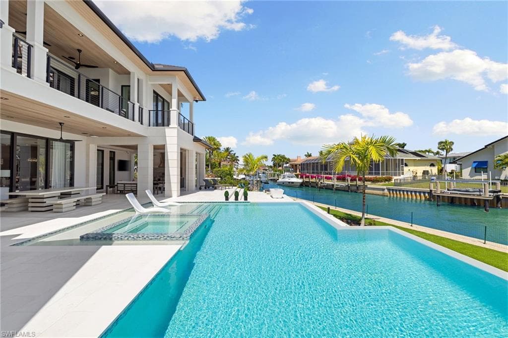 Integrated pool / spa with a balcony, a patio area, and a residential view