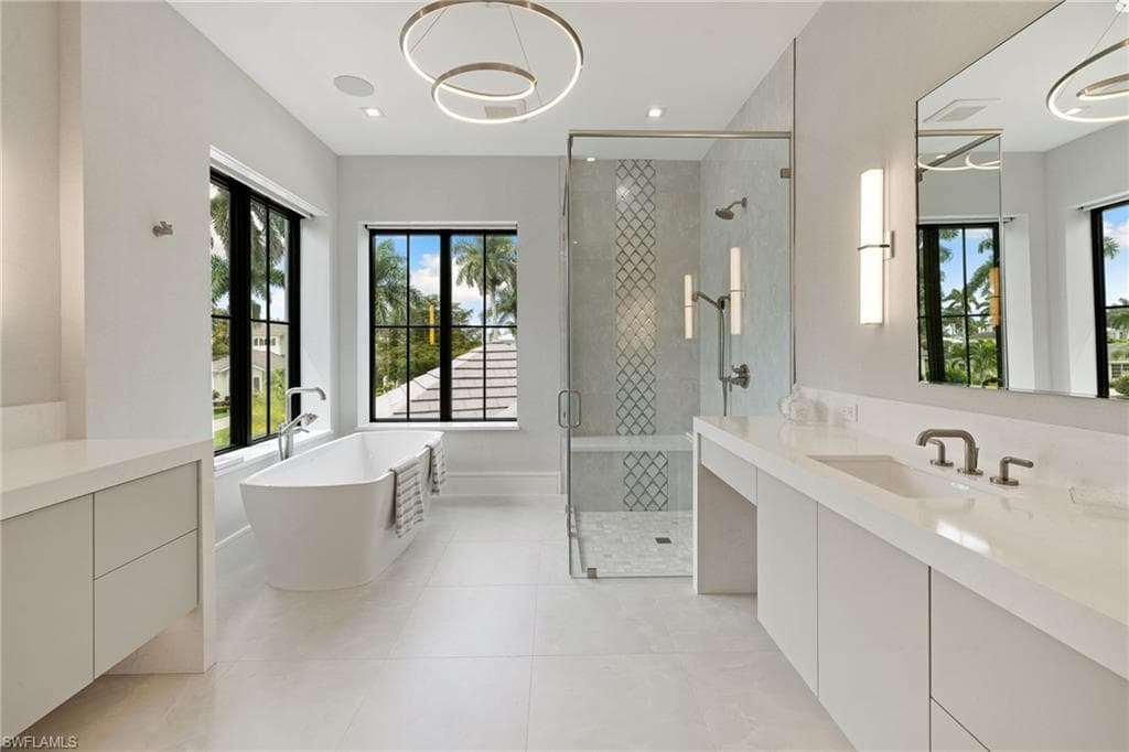 Bathroom featuring a freestanding tub, a shower stall, vanity, and light tile patterned floors