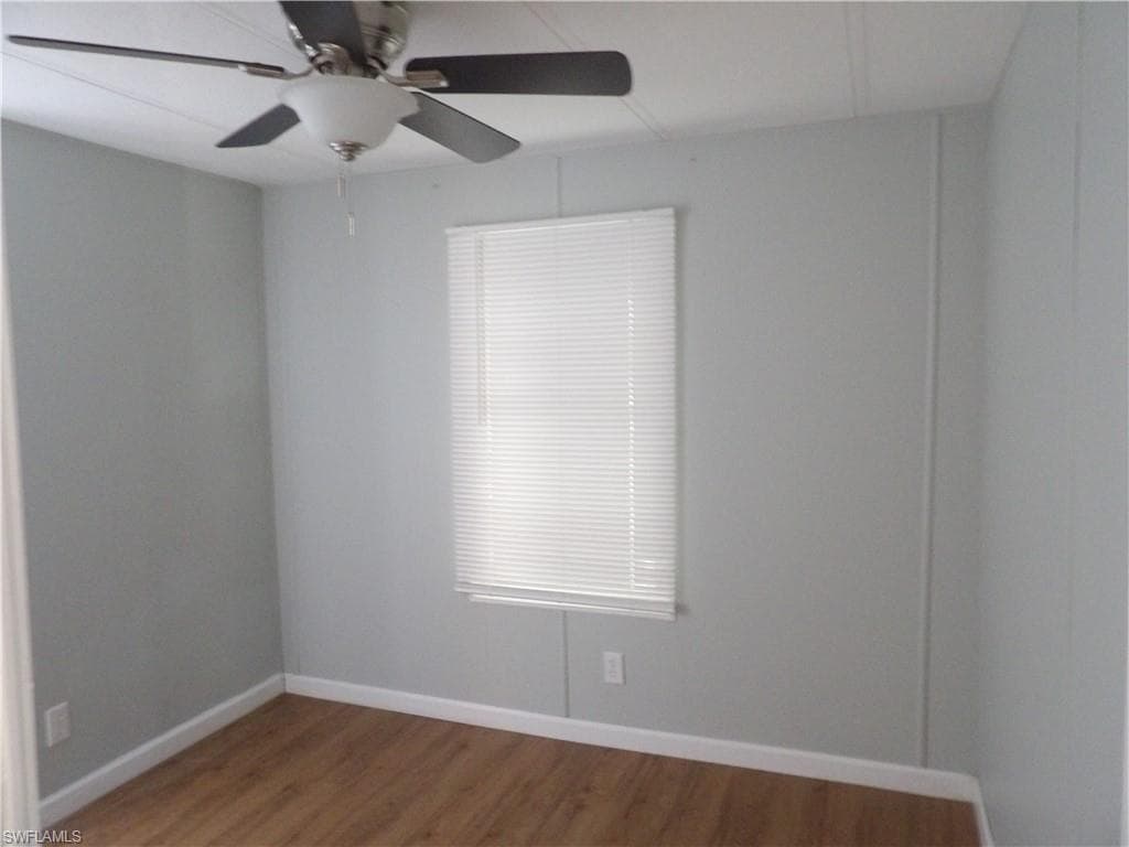 Spare room with laminated floors and a ceiling fan