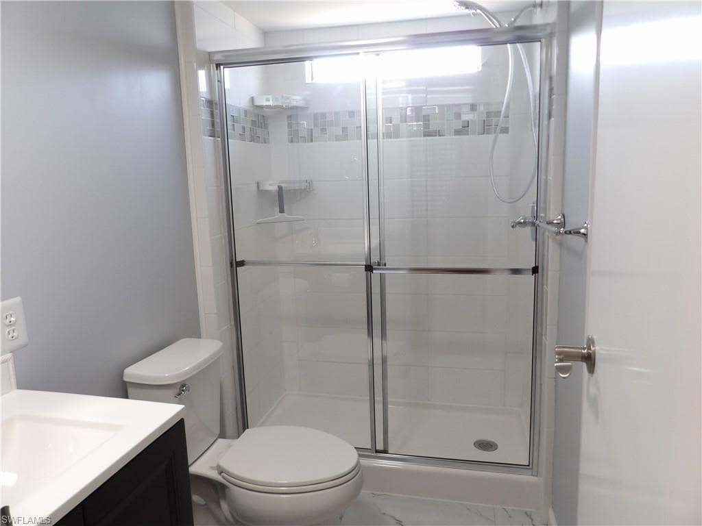 Full bath featuring vanity and a shower stall