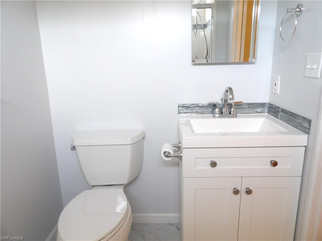 Updated Primary Bathroom with vanity and light marble finish floors