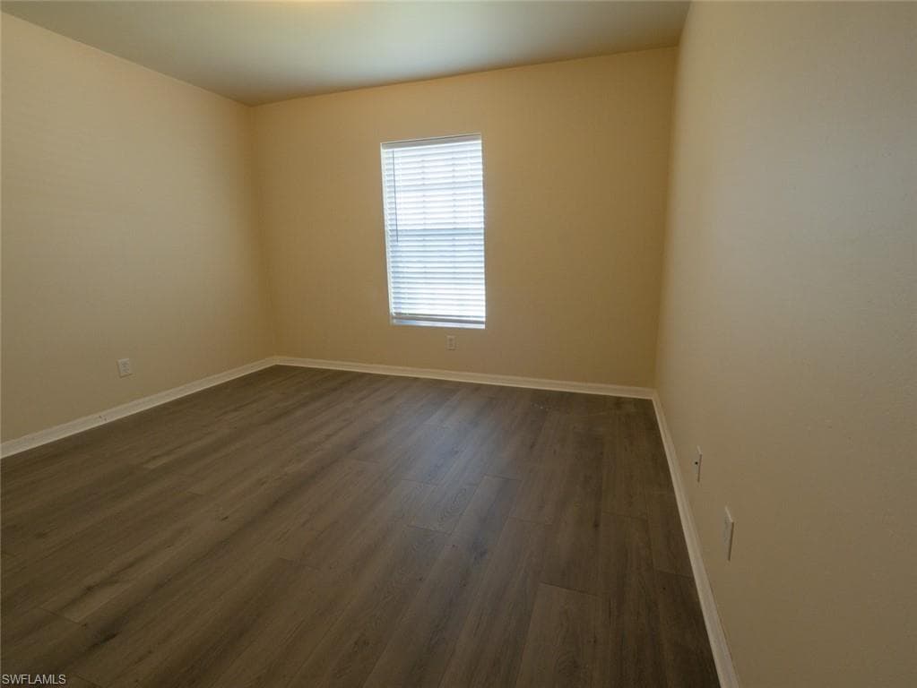 Spare room featuring dark wood-type flooring
