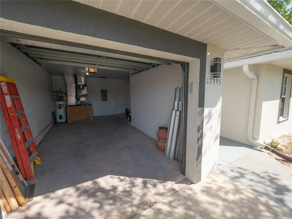 Garage featuring electric panel and electric water heater