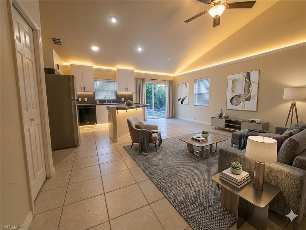 Living area featuring light tile patterned floors, lofted ceiling, a ceiling fan, and recessed lighting