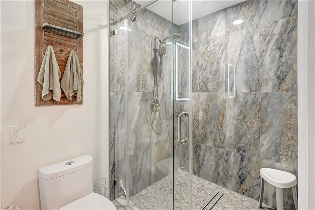 Full bath with toilet and a shower stall