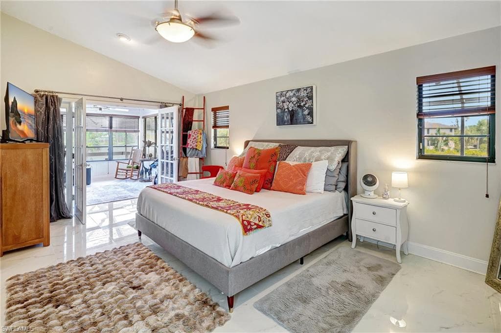 Bedroom with Lake views, baseboards, ceiling fan, and vaulted ceiling