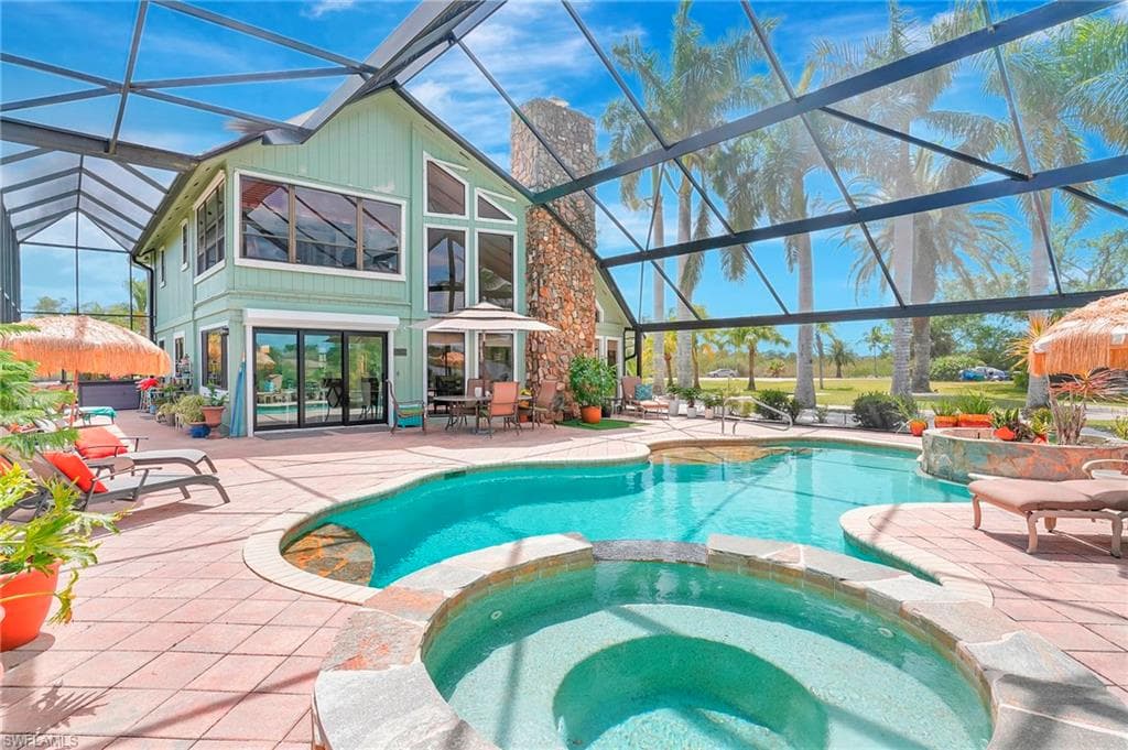 View of pool featuring a pool with connected hot tub, a lanai, and a patio