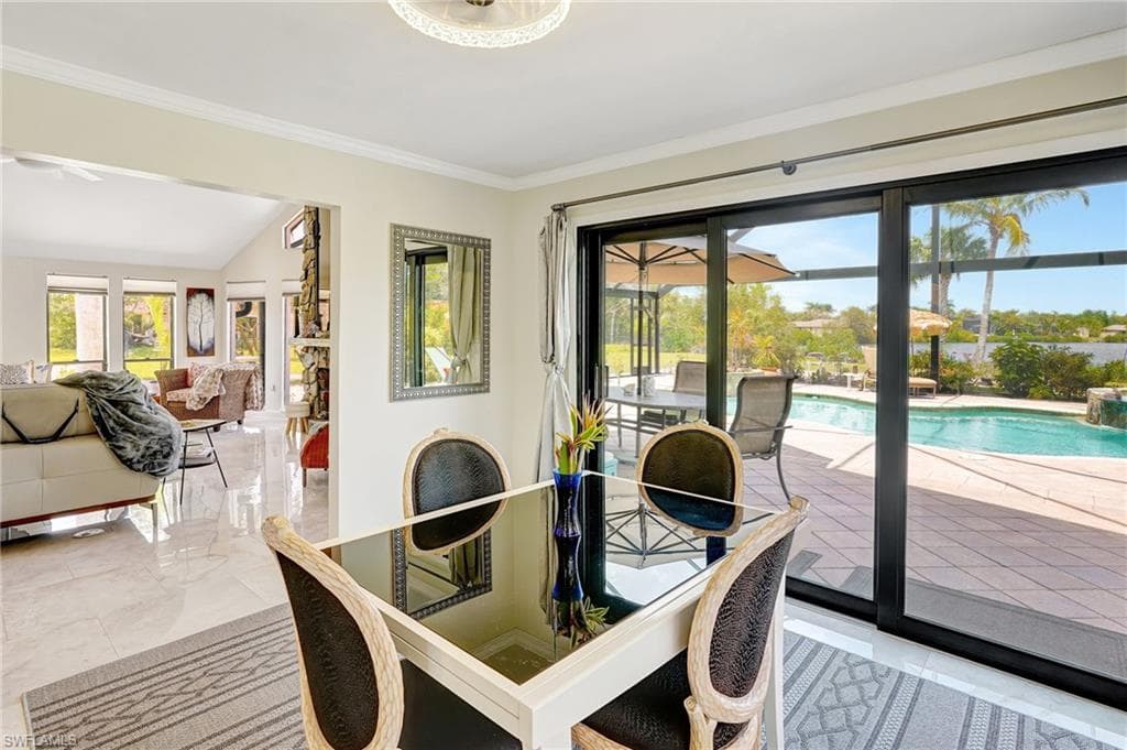 Dining space featuring marble finish floor and crown molding