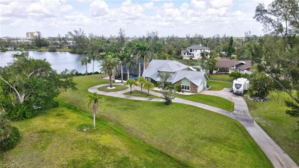 Birds eye view of property with a water view