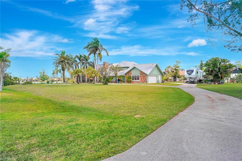 Single story home with driveway, a front yard, and a garage