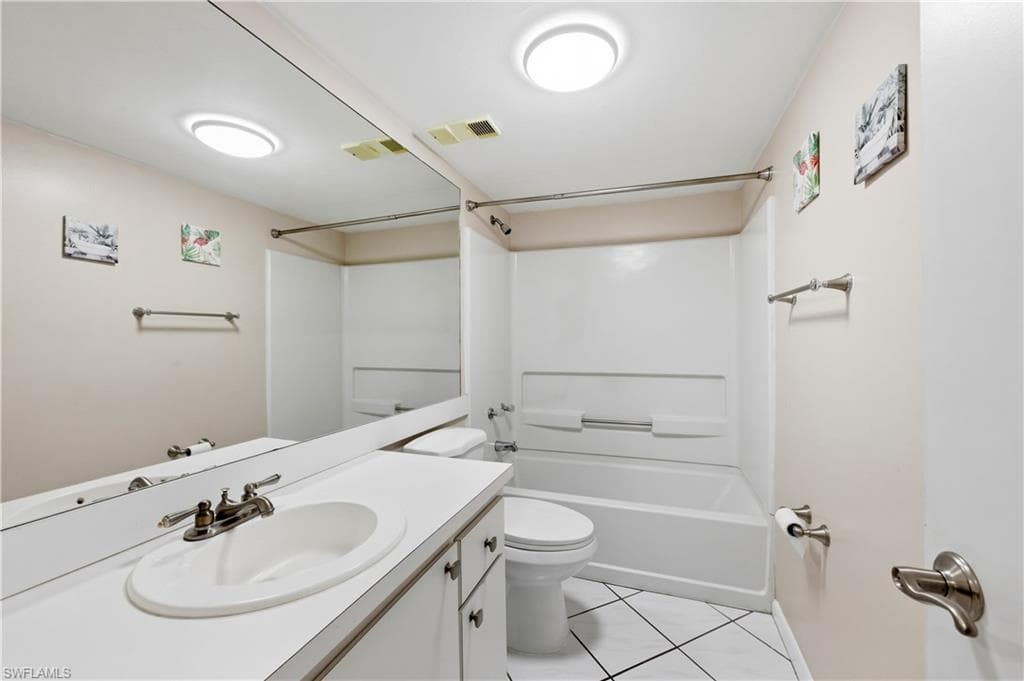 Guest Bathroom featuring vanity, bathtub / shower combination, and light tile patterned flooring