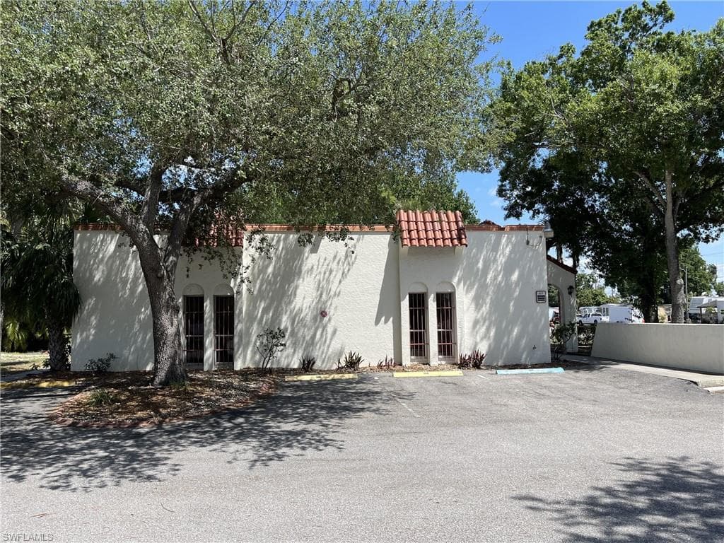 View of building exterior featuring uncovered parking