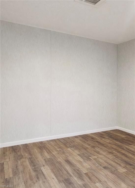 Unfurnished room with dark wood-type flooring and baseboards
