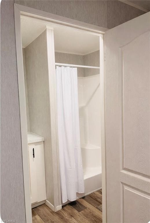 Bathroom featuring light wood-style floors and shower / tub combo