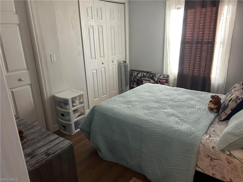 Bedroom featuring dark wood-type flooring and a closet