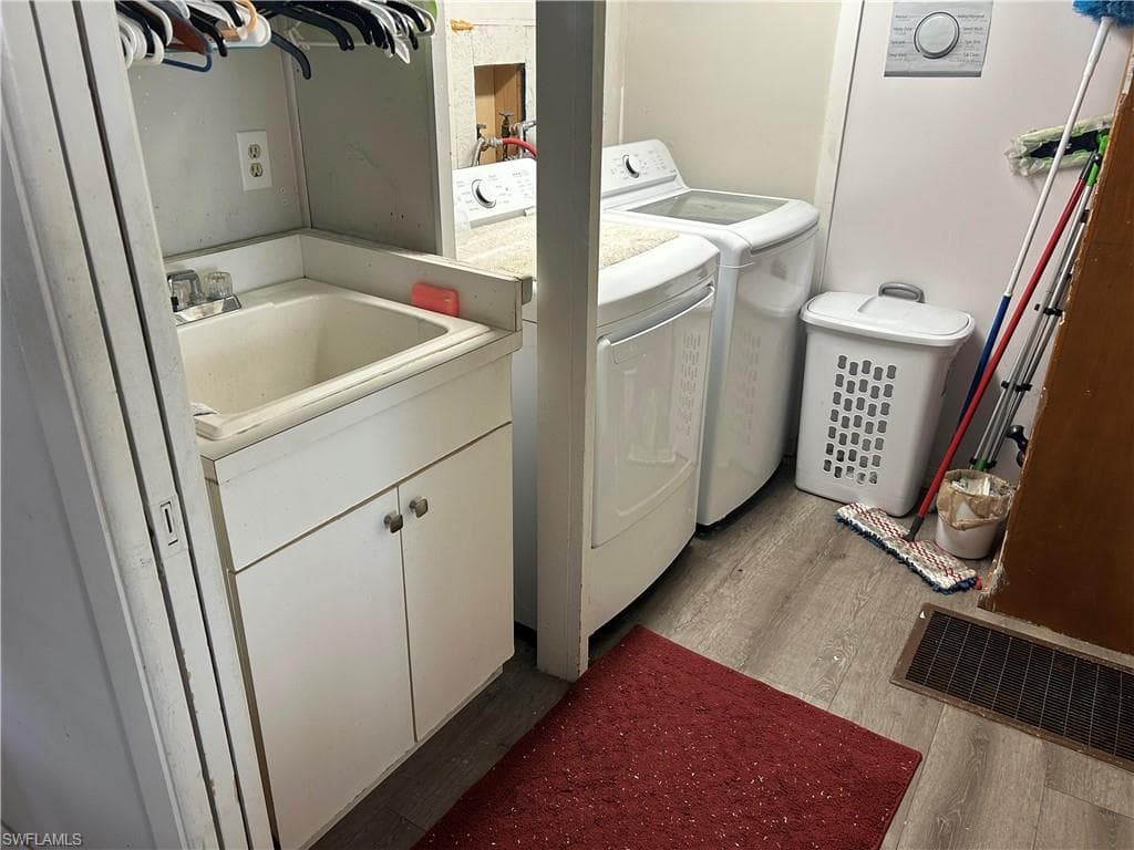 Laundry area featuring light wood-type flooring and independent washer and dryer