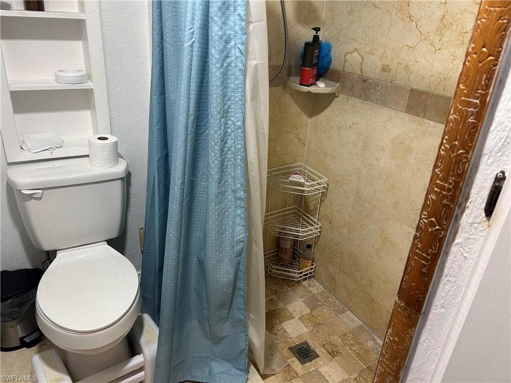 Full bath with a shower stall and toilet