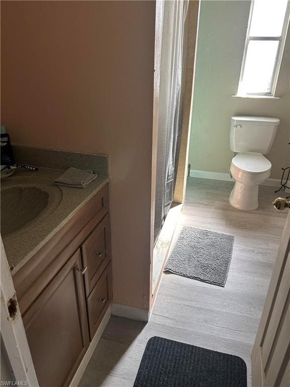 Bathroom with vanity, a shower with shower curtain, and light wood finished floors