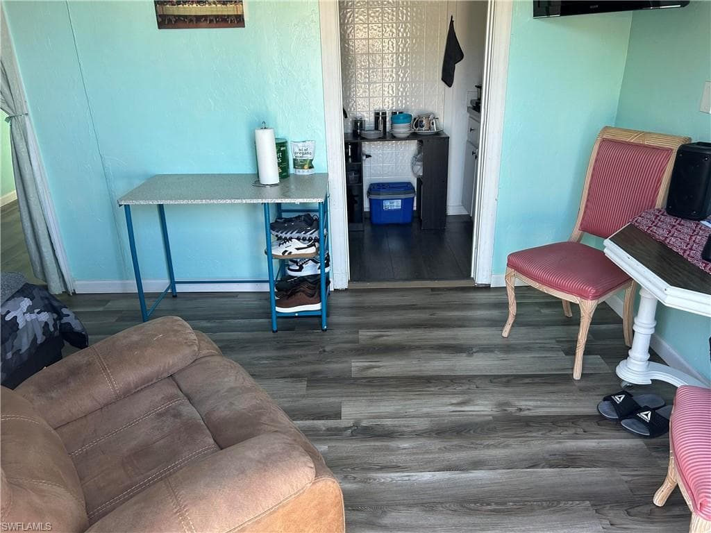Living area featuring dark wood finished floors and baseboards