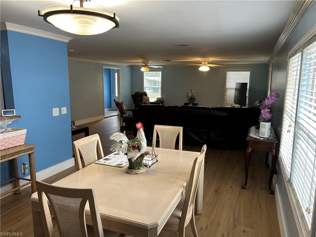 Dining area featuring ornamental molding, vinyl finished floors, and a ceiling fan