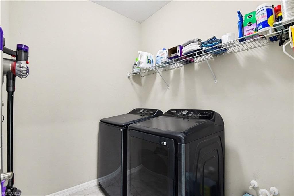 Laundry area with washer and dryer and baseboards
