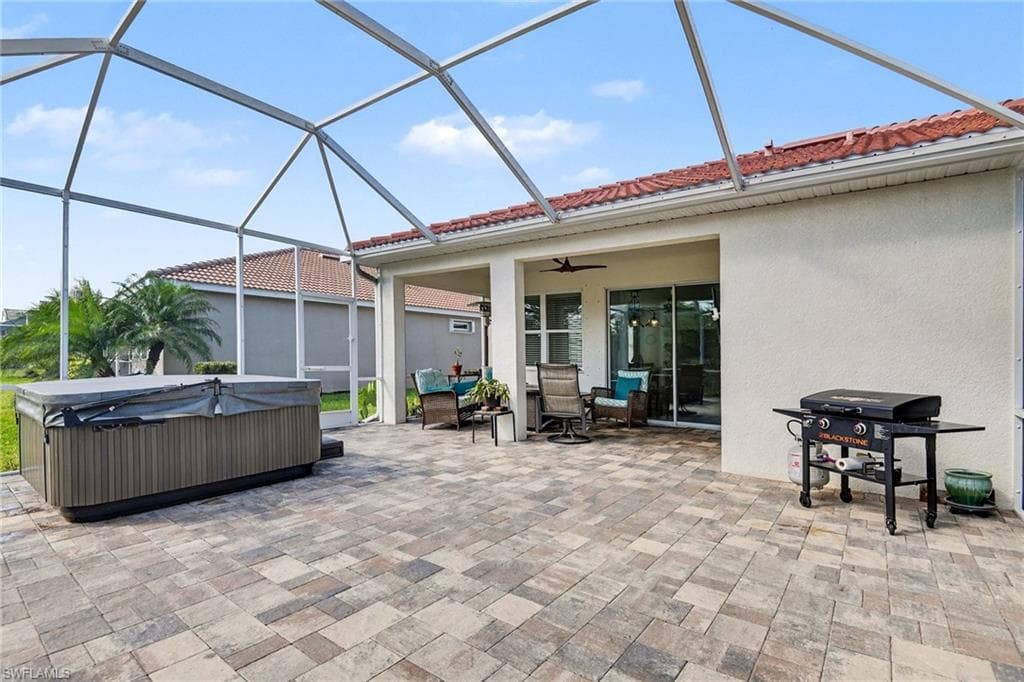View of patio featuring a sunroom, area for grilling, ceiling fan, and a lanai