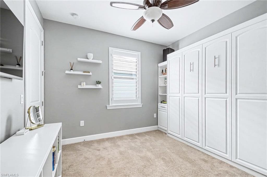 Unfurnished office featuring light colored carpet and ceiling fan