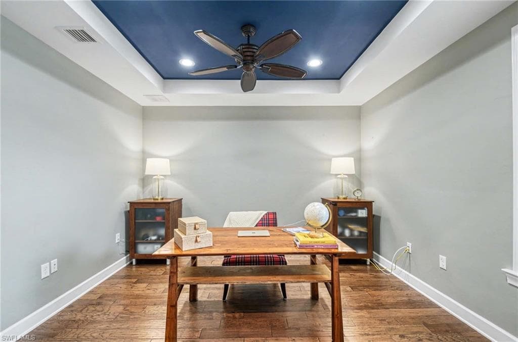 Dining area featuring a raised ceiling, hardwood / wood-style floors, an office area, ceiling fan, and recessed lighting
