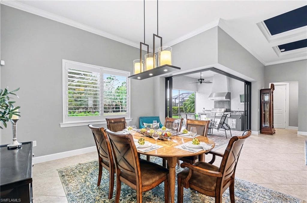 Dining area featuring crown molding, light tile patterned floors, and a ceiling fan