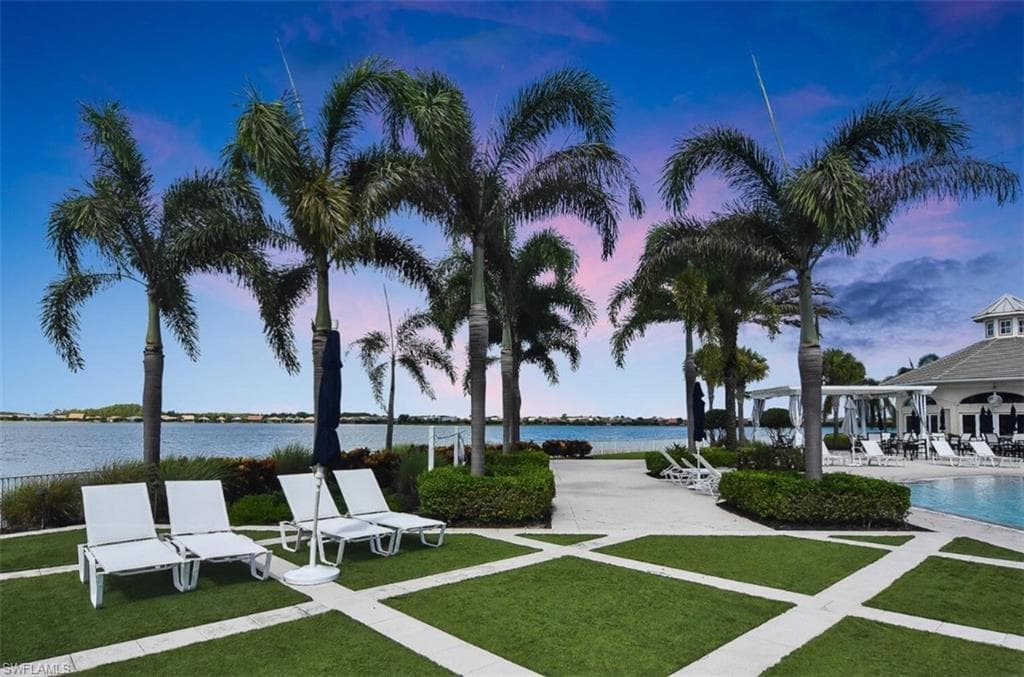 View of property's community featuring a patio area, a water view, and a swimming pool