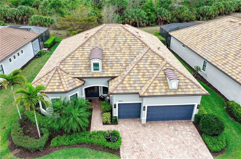 Contemporary stucco exterior with a multi-toned tile roof and two dormer windows