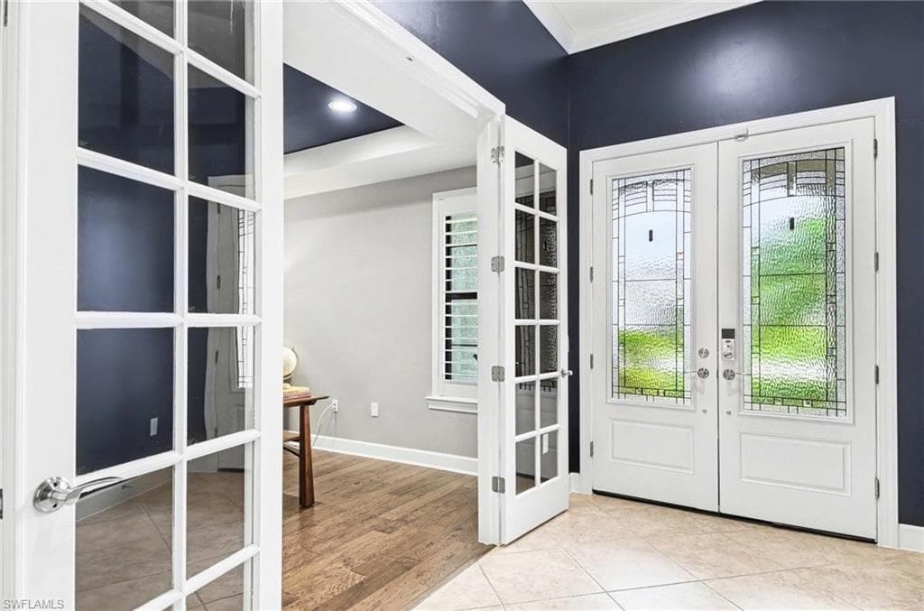 Entryway with french doors, light tile patterned flooring, crown molding, and recessed lighting