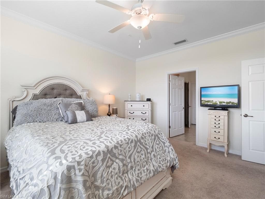 Bedroom featuring ornamental molding, light carpet, and ceiling fan