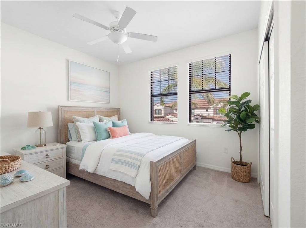 Bedroom with carpet, ceiling fan, a desk, and a closet