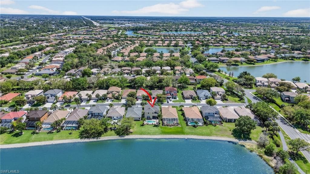 Aerial view of property's location featuring a large body of water and nearby suburban area