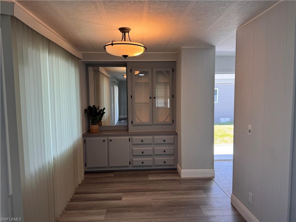 Dining area with built in credenza and overhead lighting, windows looks out into sunroom