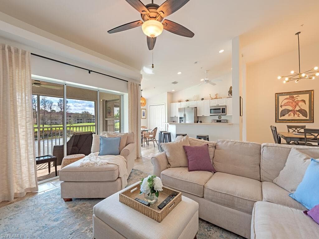 Living area with ceiling fan, lofted ceiling, suspended lighting.