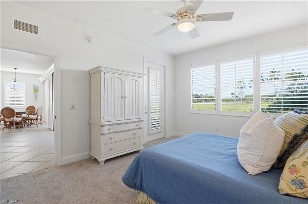 Bedroom with light carpet, ceiling fan, and access to exterior