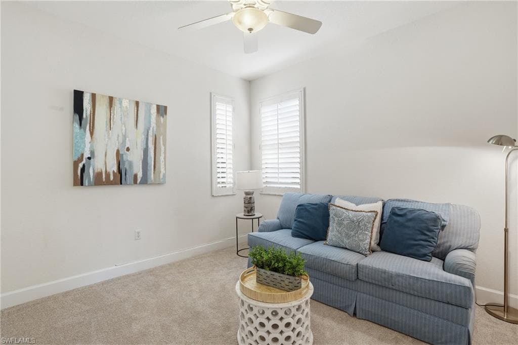 Living area with light colored carpet and ceiling fan