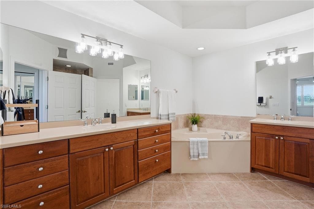 Bathroom featuring two vanities and a garden tub