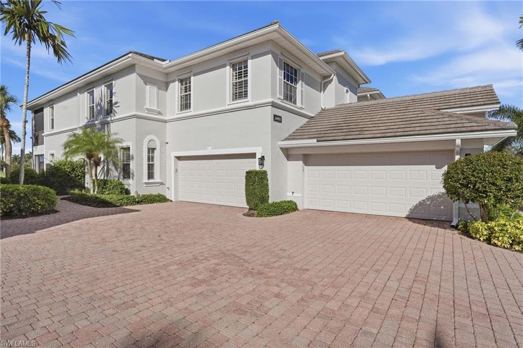 View of front facade with decorative driveway and stucco siding